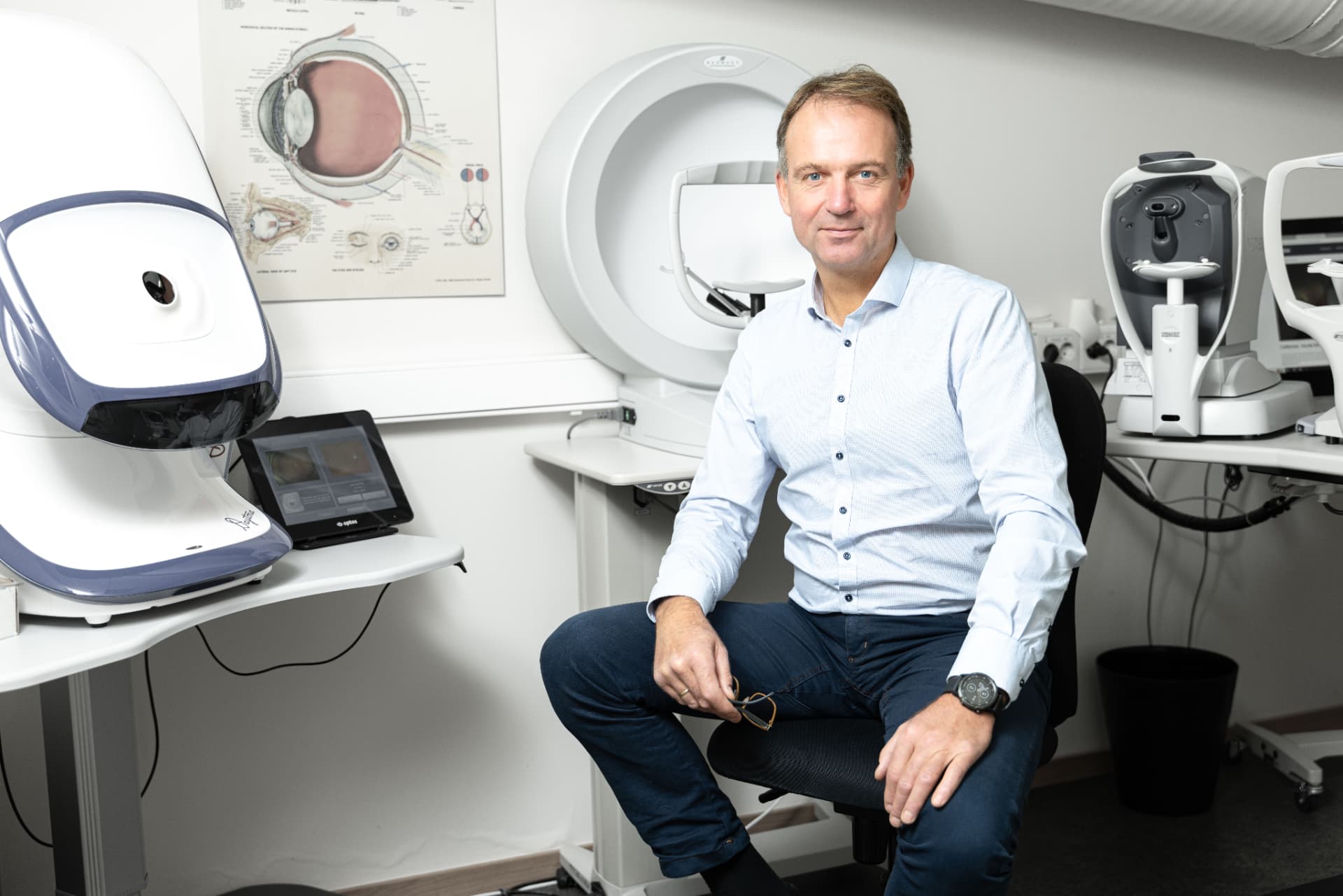 Optiker og eier Arnt Corneliussen i undersøkelsesrommet med Optomap og OCT